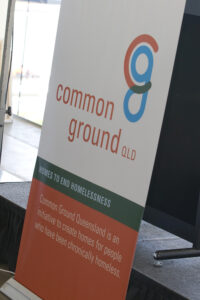 Common Ground Queensland poster at an event. 